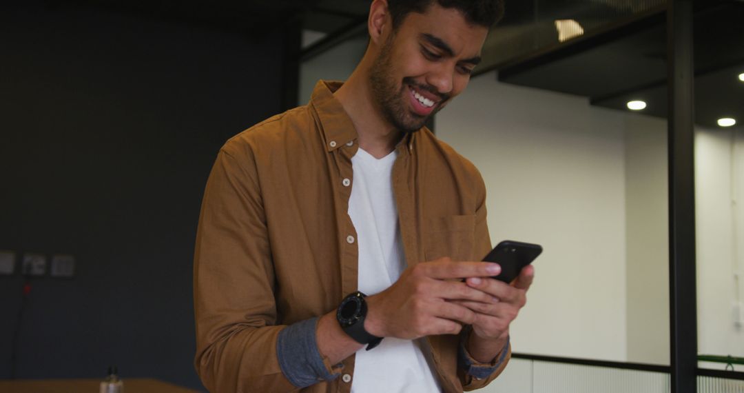 Smiling Man Using Smartphone in Modern Office - Free Images, Stock Photos and Pictures on Pikwizard.com