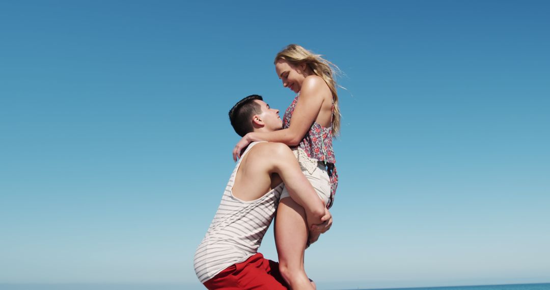 Young Couple Enjoying Romantic Beach Date Under Clear Blue Sky - Free Images, Stock Photos and Pictures on Pikwizard.com