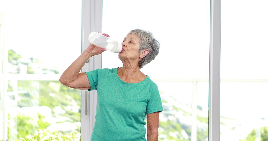 Senior Woman Refreshing with Water While Taking Break at Home - Free Images, Stock Photos and Pictures on Pikwizard.com