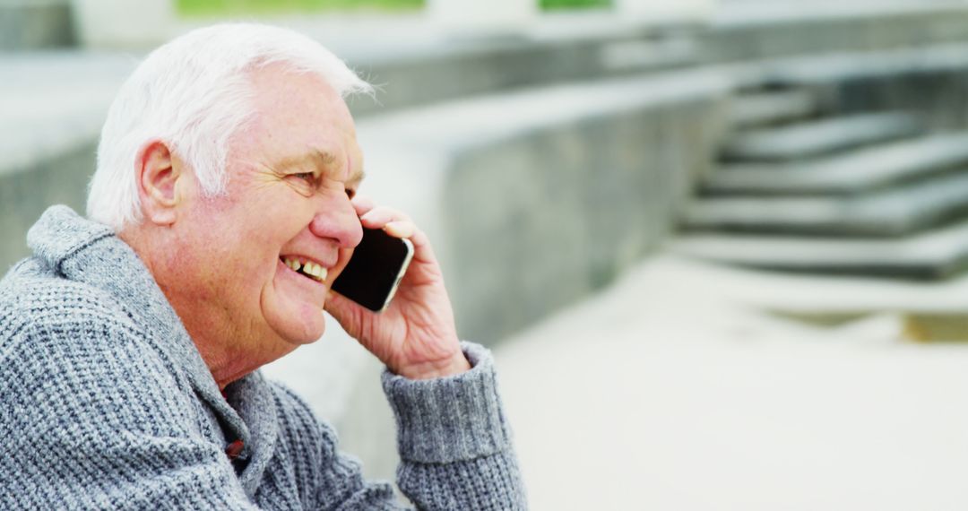 Elderly Man Smiling While Talking on Smartphone Outdoors - Free Images, Stock Photos and Pictures on Pikwizard.com