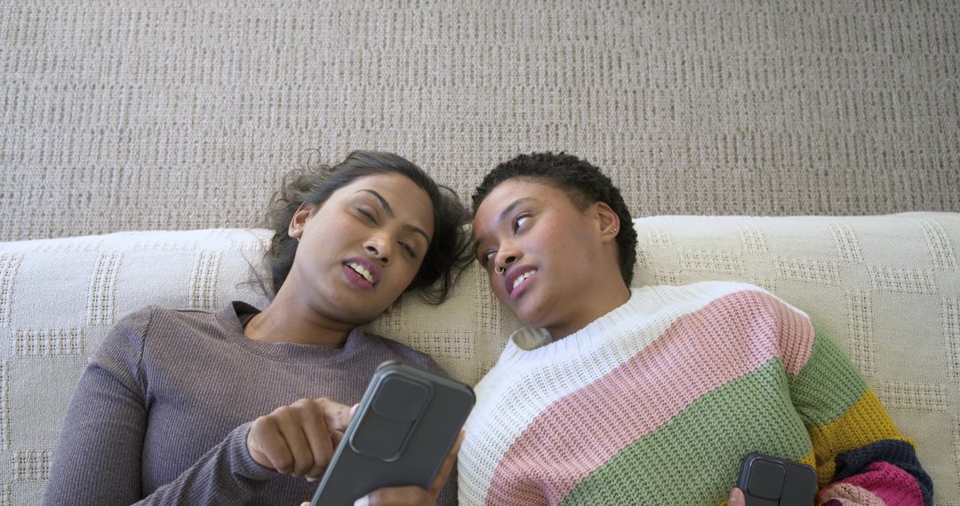 Diverse Friends Relaxing at Home Sharing Smartphone Content