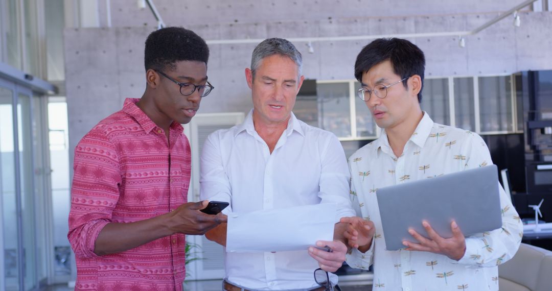 Multi-Ethnic Business Team Discussing Document in Modern Office