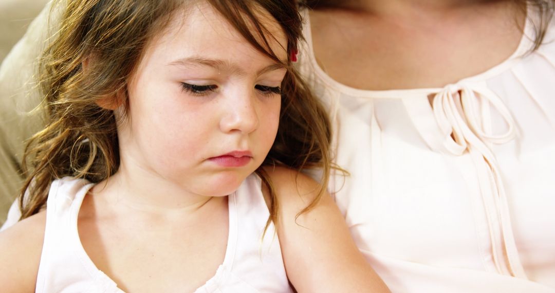 Young Girl Sitting with Adult Showing Sad Expression - Free Images, Stock Photos and Pictures on Pikwizard.com