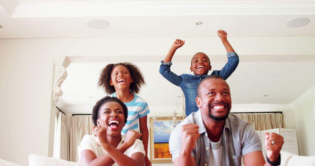 Excited African American Family Celebrating Victory Together at Home - Free Images, Stock Photos and Pictures on Pikwizard.com