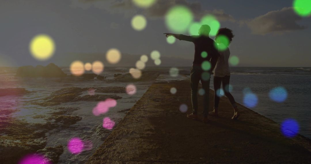 Couple Admiring Ocean Sunset with Colorful Bokeh Lighting