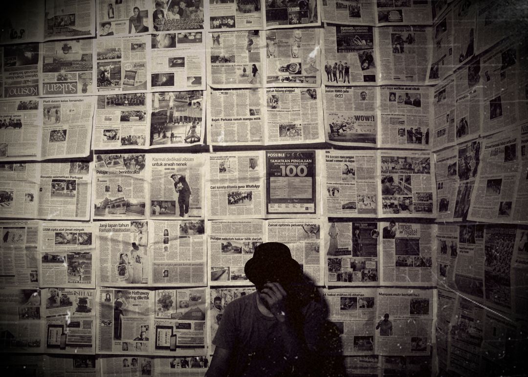Person Standing Against Newspaper Clad Wall in Vintage Setting - Free Images, Stock Photos and Pictures on Pikwizard.com