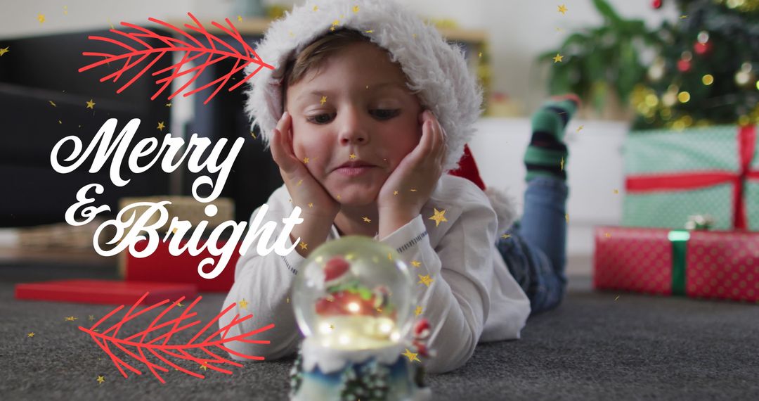 Child Celebrating Christmas Lying with Snow Globe