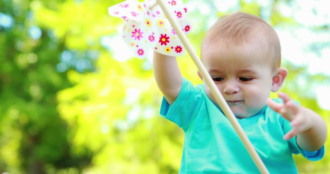 Happy Baby Playing with Pinwheel in Sunny Park - Free Images, Stock Photos and Pictures on Pikwizard.com