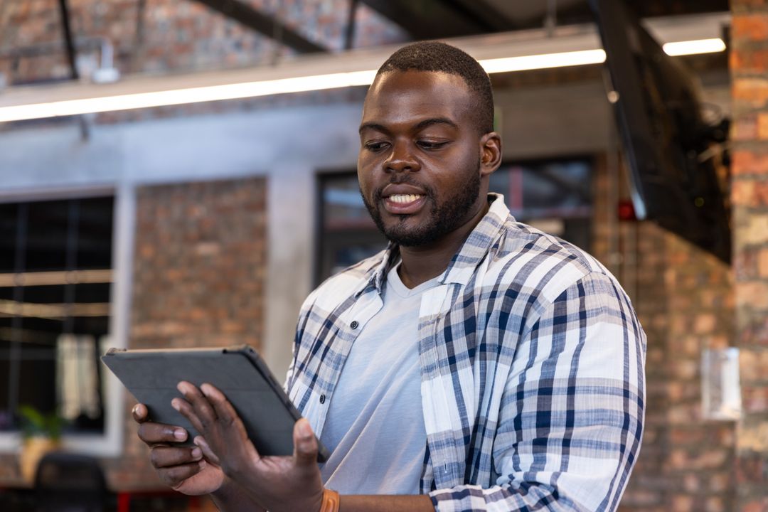 Professional Analyzing Data on Tablet in Modern Loft Office