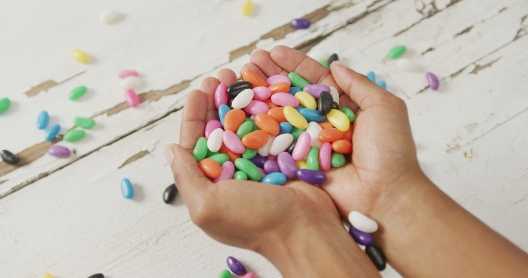 Colorful Candy-Filled Hands on Rustic White Background - Free Images, Stock Photos and Pictures on Pikwizard.com