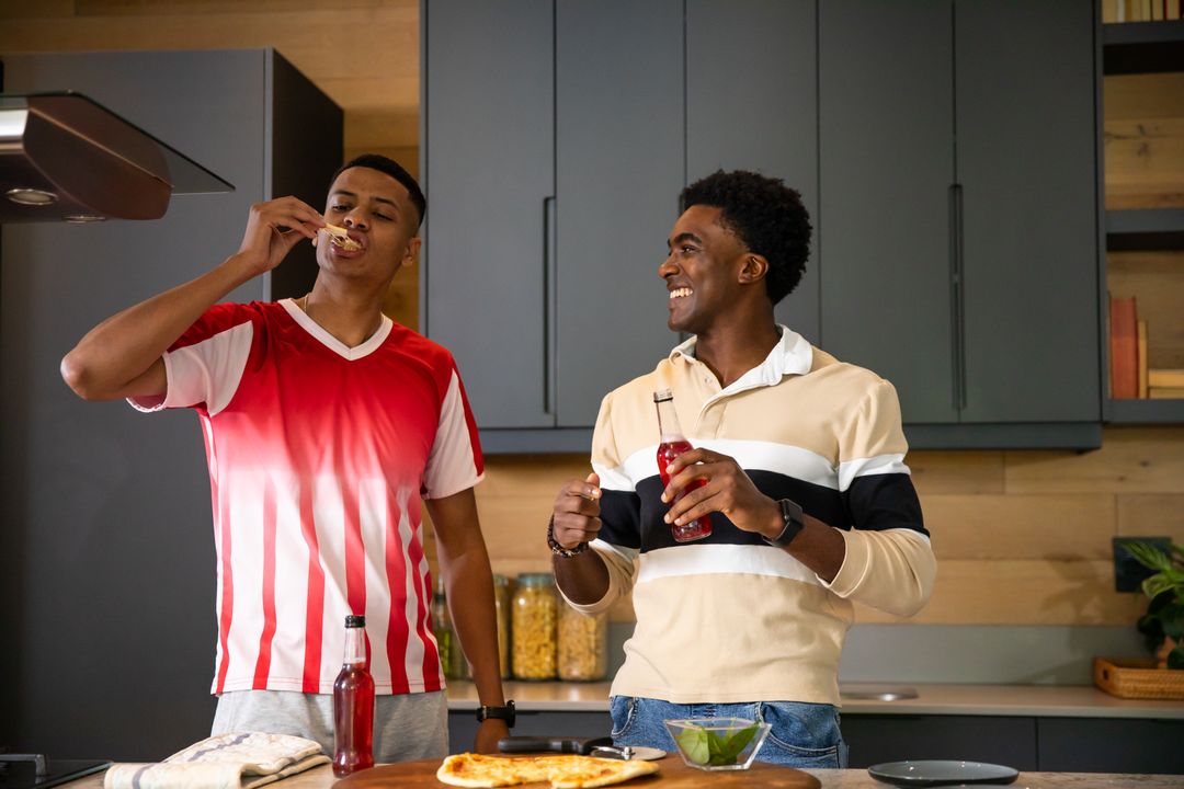 Diverse Friends Enjoying Pizza and Refreshments in Kitchen