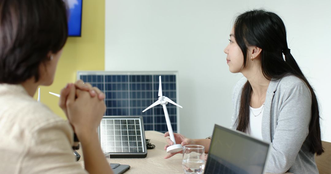 Team Discussing Renewable Energy Models in Office