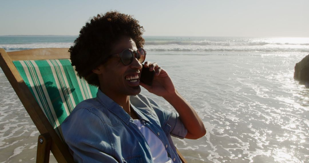 Smiling Man Enjoying Beach Day While Talking on Phone - Free Images, Stock Photos and Pictures on Pikwizard.com