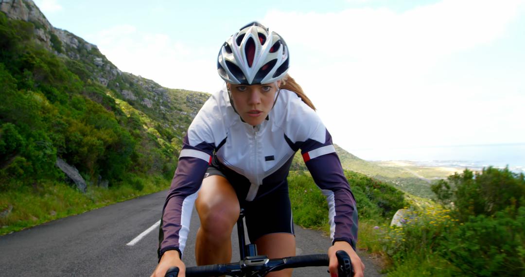 Focused Female Cyclist Racing on Rural Road - Free Images, Stock Photos and Pictures on Pikwizard.com