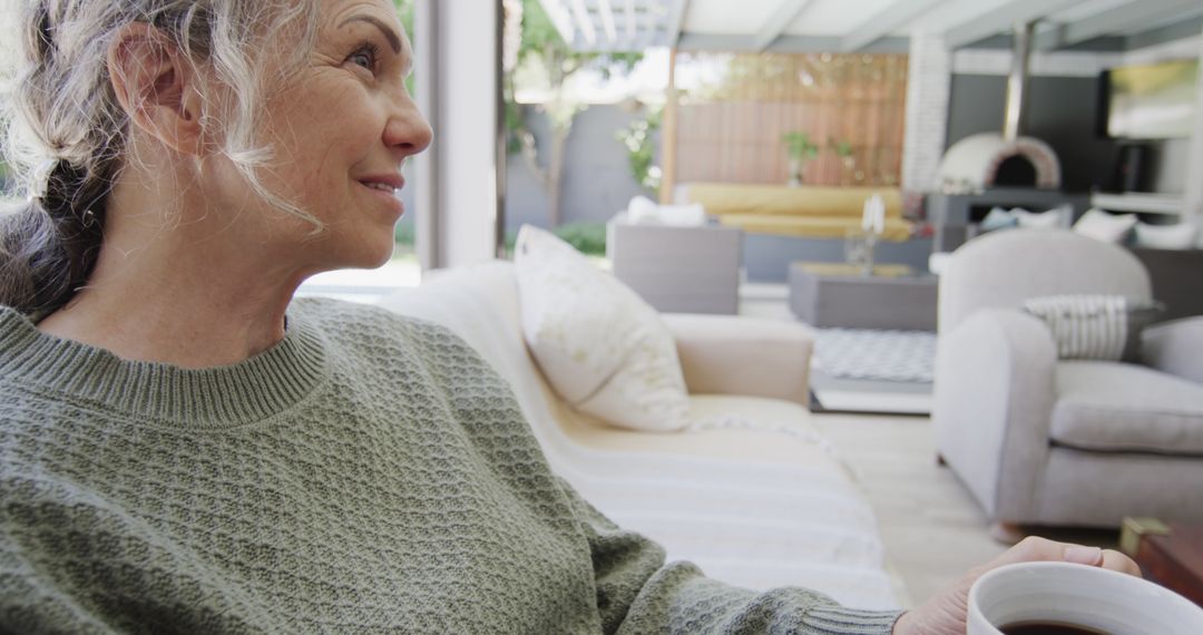 Elderly Woman Relaxing with Coffee in Modern Outdoor Living Space - Free Images, Stock Photos and Pictures on Pikwizard.com