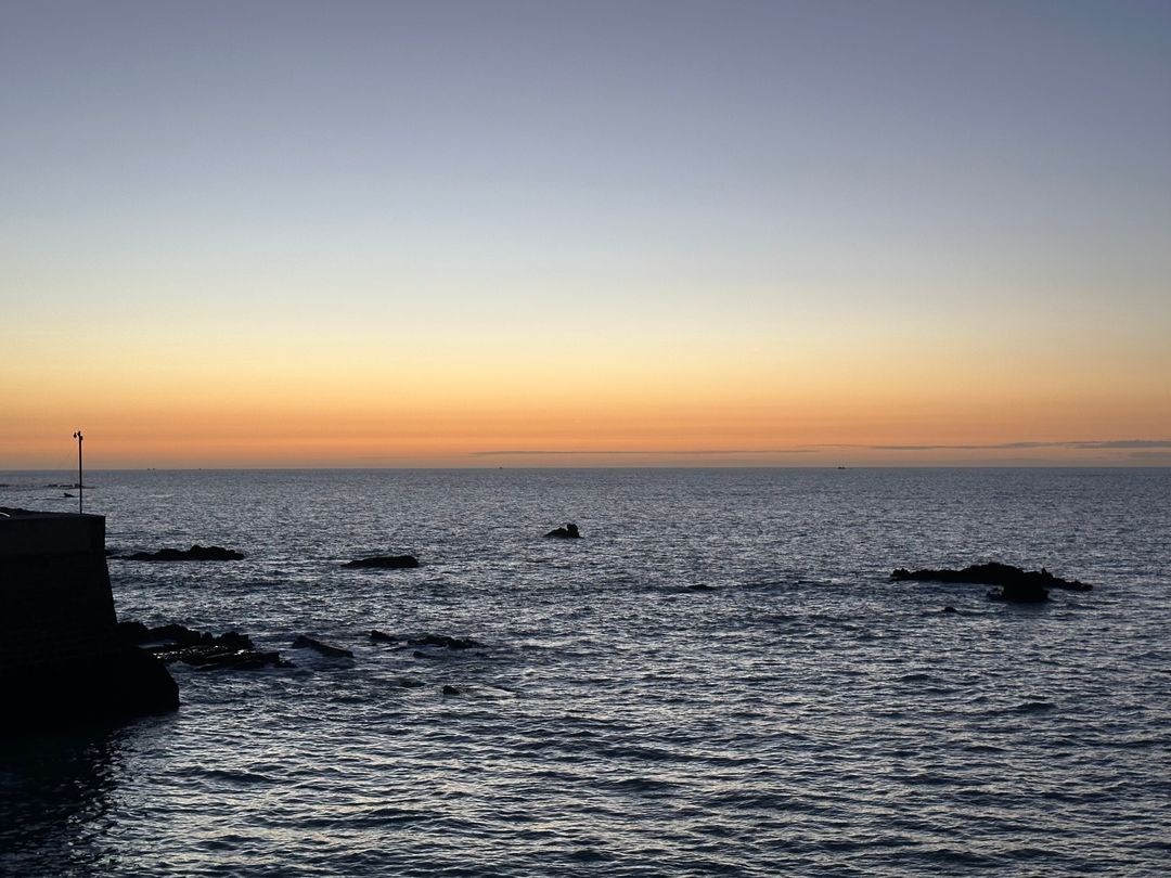 Tranquil beach at dusk with vibrant horizon
