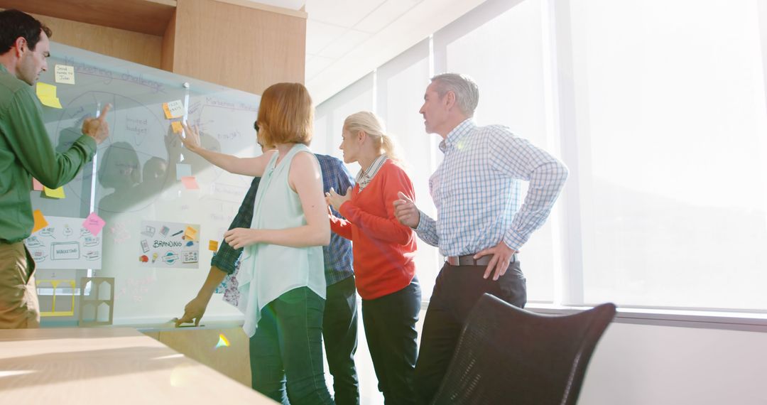 Team Collaborating on Brainstorming Session with Glass Wall