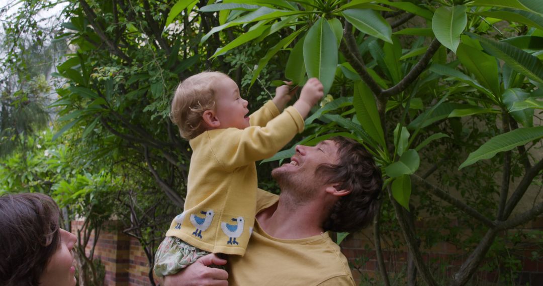 Father Holding Child Near Tree, Enjoying Nature Outdoors - Free Images, Stock Photos and Pictures on Pikwizard.com