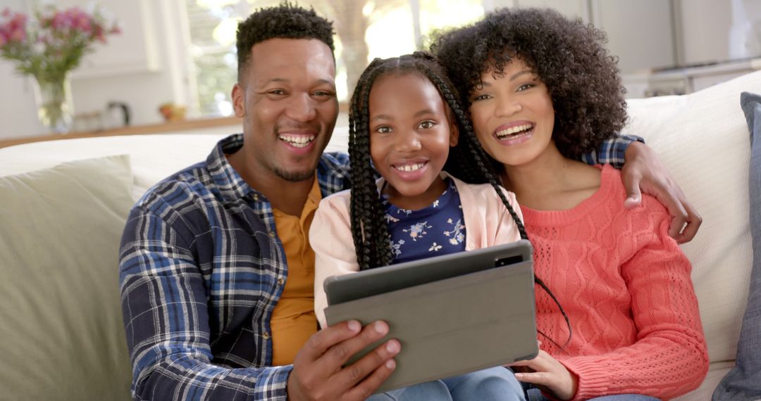 Happy African American Family Watching Tablet Together on Couch - Free Images, Stock Photos and Pictures on Pikwizard.com