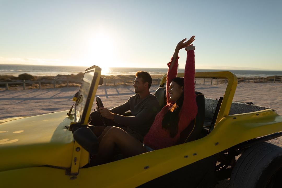 Happy Caucasian Couple Driving Beach Buggy at Sunset - Free Images, Stock Photos and Pictures on Pikwizard.com