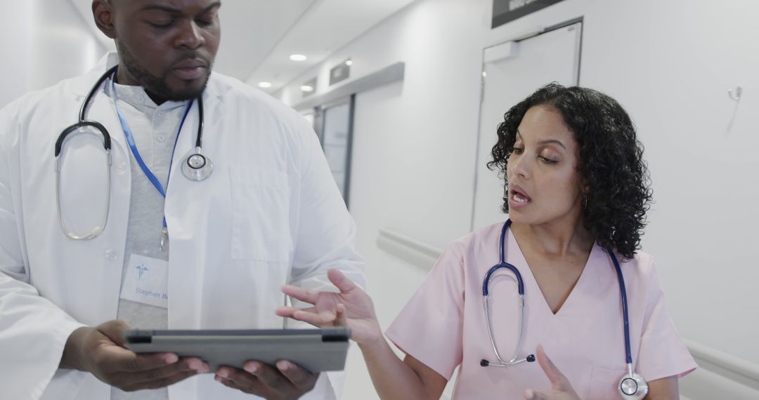 Health professionals discussing patient data in hospital corridor - Free Images, Stock Photos and Pictures on Pikwizard.com