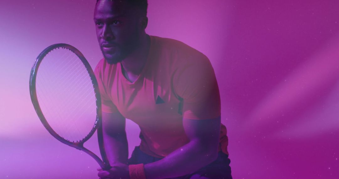 Focused Tennis Player Holding Racket in Colorful Lighting
