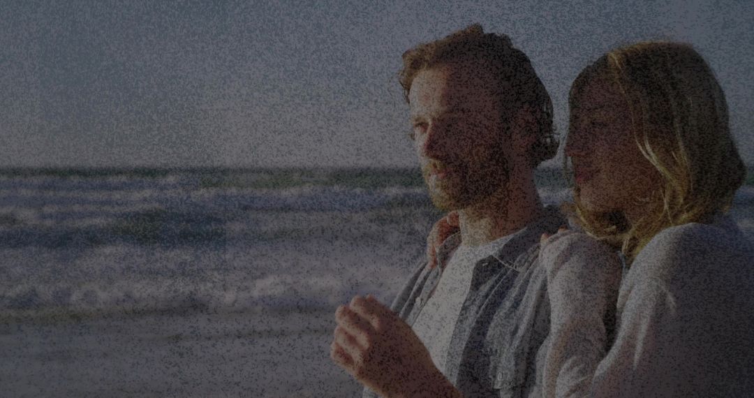 Romantic Couple Embracing on Sunny Beachfront with Waves