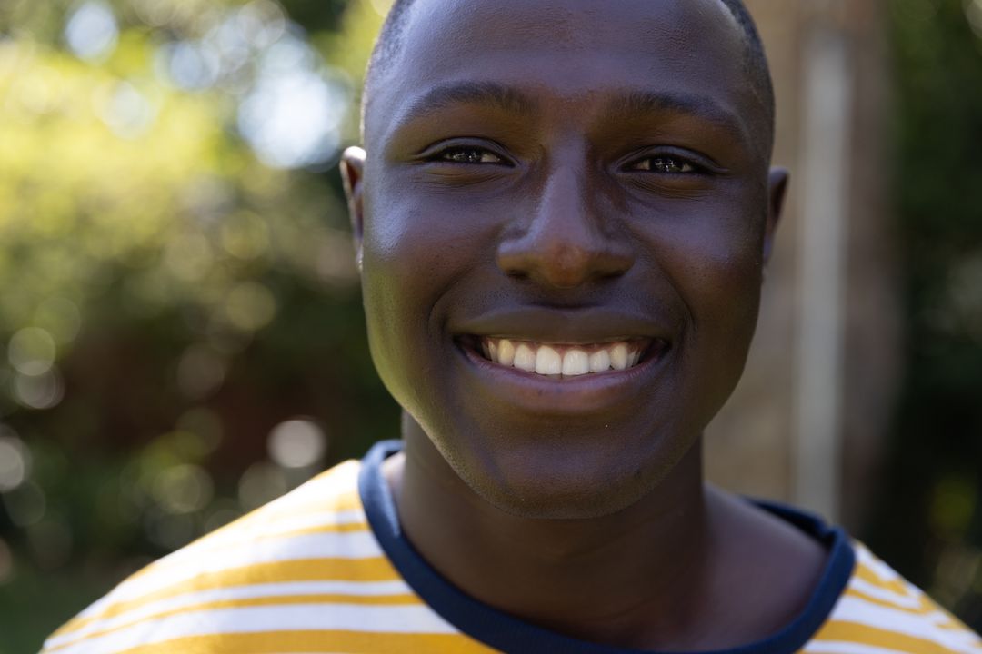 Joyful Young Man Smiling in Vibrant Garden Setting