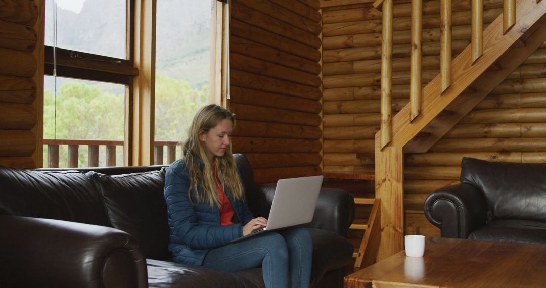 Young Woman Working on Laptop in Cozy Wooden Cabin - Free Images, Stock Photos and Pictures on Pikwizard.com