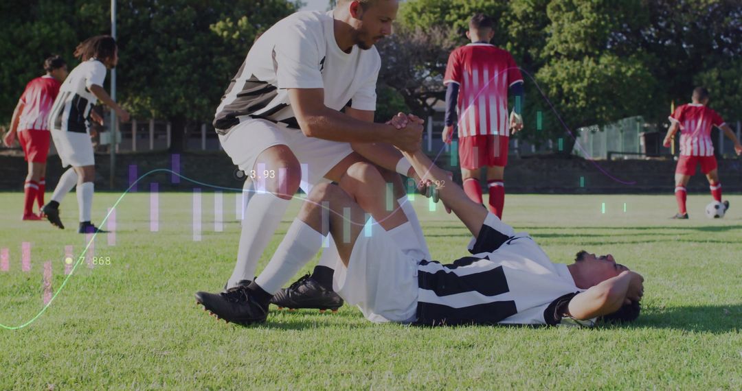 Teammate Assisting Injured Player on Soccer Field