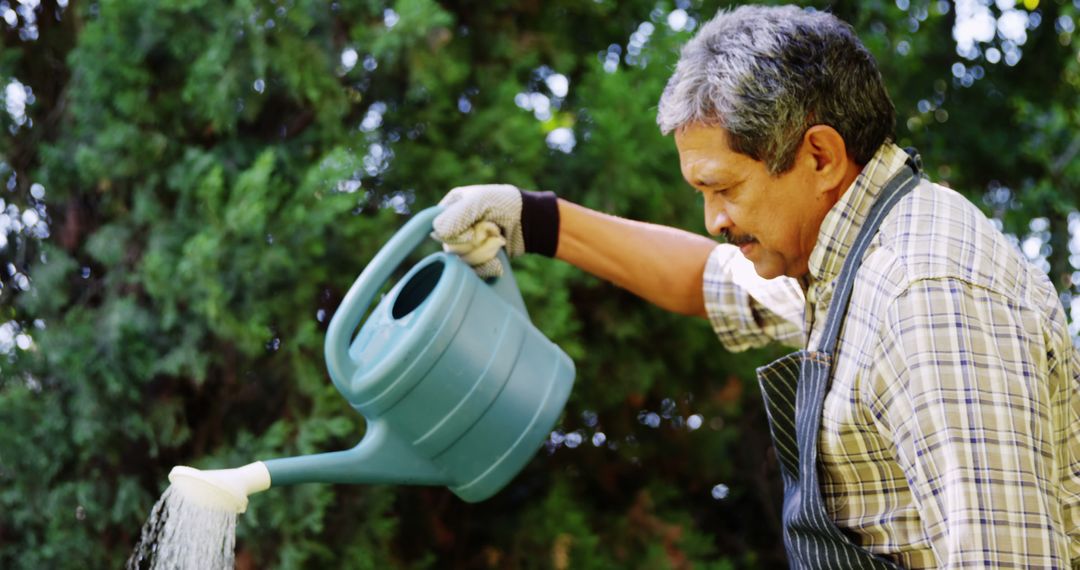 Senior Man Watering Garden with Watering Can in Backyard - Free Images, Stock Photos and Pictures on Pikwizard.com