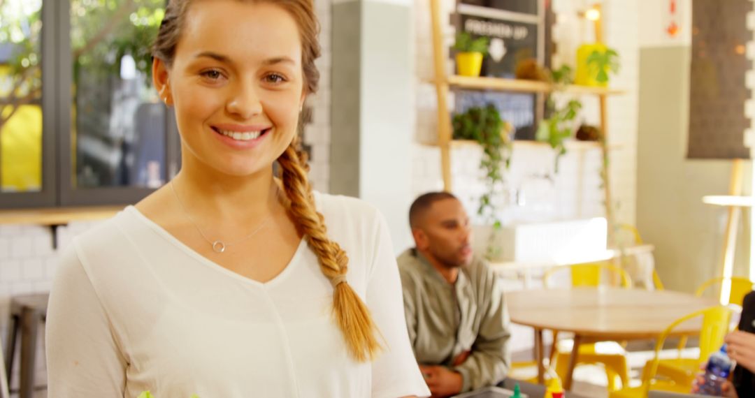 Smiling Young Woman in Casual Cafe with Diverse Background - Free Images, Stock Photos and Pictures on Pikwizard.com