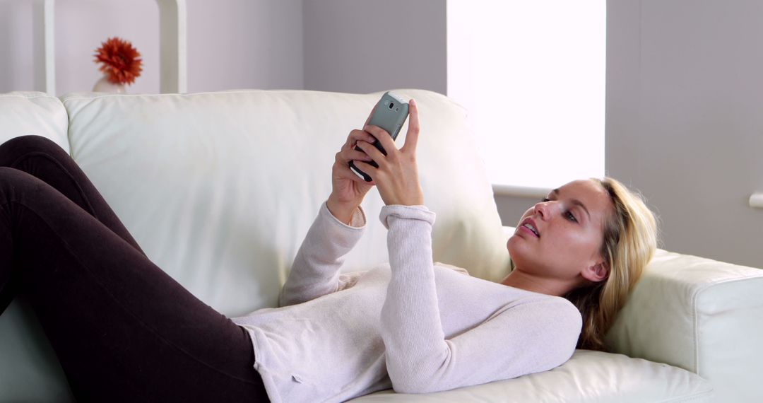 Woman Relaxing on Couch and Using Smartphone at Home - Free Images, Stock Photos and Pictures on Pikwizard.com