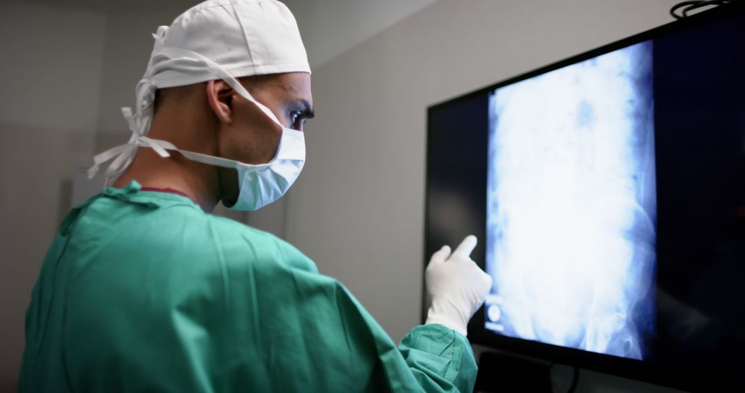 Surgeon Analyzing X-Ray Image on Monitor During Medical Procedure - Free Images, Stock Photos and Pictures on Pikwizard.com