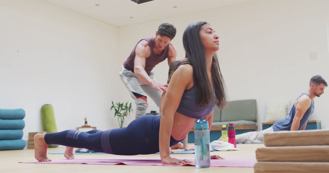 Diverse Group Yoga Class with Instructor Assistance