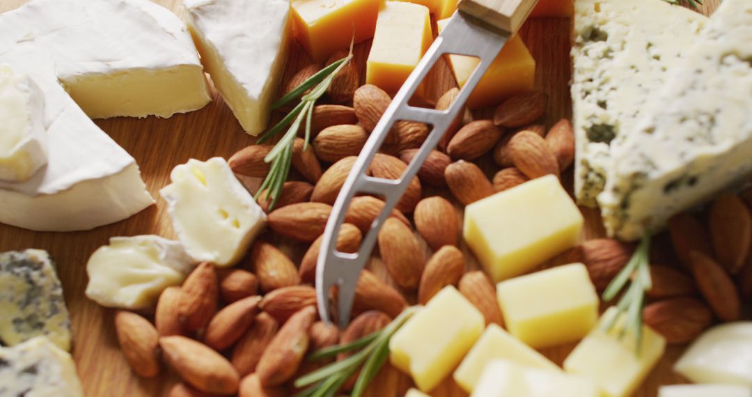 Assorted Cheeses and Almonds with Cheese Knife on Wooden Board - Free Images, Stock Photos and Pictures on Pikwizard.com