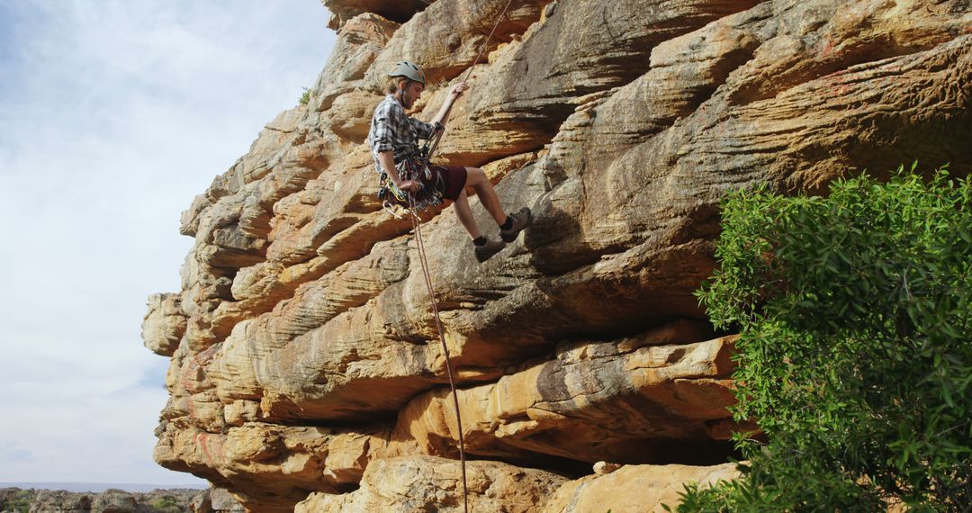 Adventurous Climber Rappelling Down Rocky Cliff - Free Images, Stock Photos and Pictures on Pikwizard.com