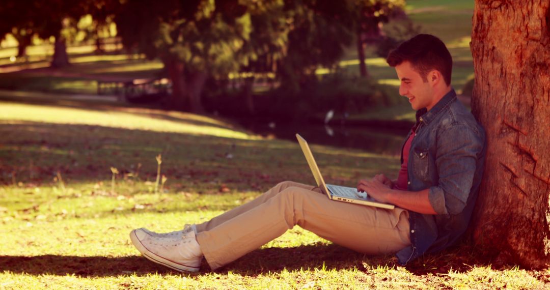 Young Man Working on Laptop Outdoors in Sunny Park - Free Images, Stock Photos and Pictures on Pikwizard.com