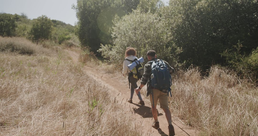 Couple Enjoying a Hiking Adventure in Sunlit Nature