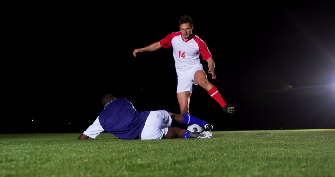 Soccer Players Competing During Night Match on Field - Free Images, Stock Photos and Pictures on Pikwizard.com