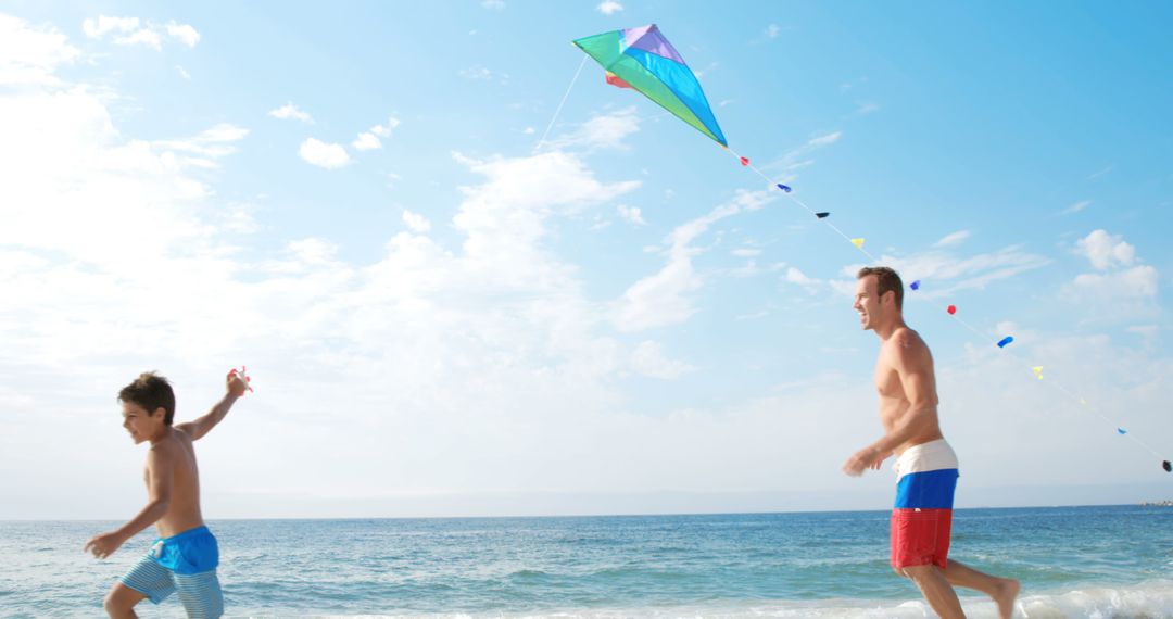 Father and Son Flying Kite on Sunny Beach - Free Images, Stock Photos and Pictures on Pikwizard.com