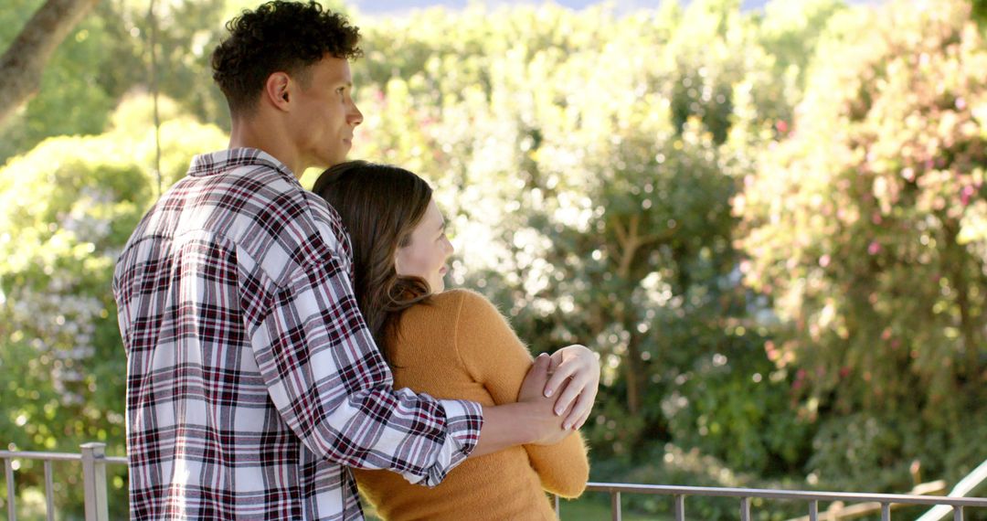 Diverse Couple Embracing on Sunny Balcony