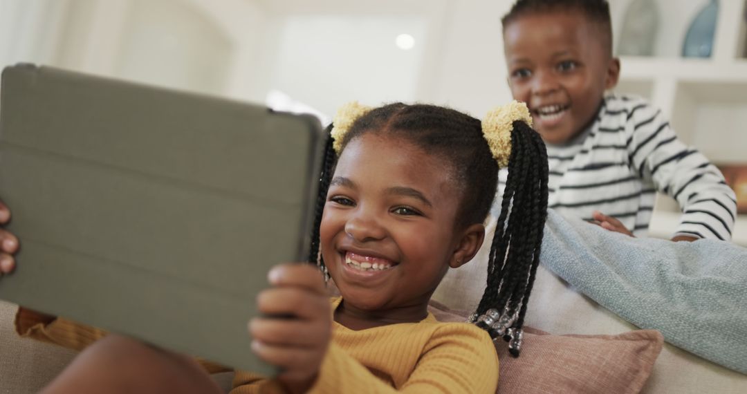 Smiling African American Kids Using Tablet Together at Home - Free Images, Stock Photos and Pictures on Pikwizard.com