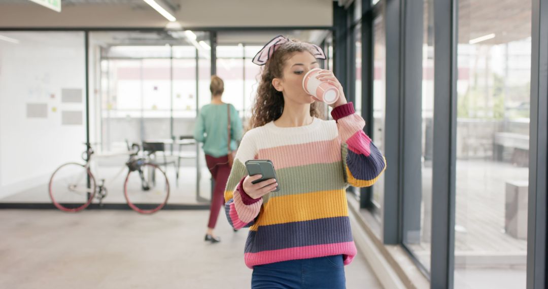 Young Woman Drinking Coffee While Using Smartphone - Free Images, Stock Photos and Pictures on Pikwizard.com