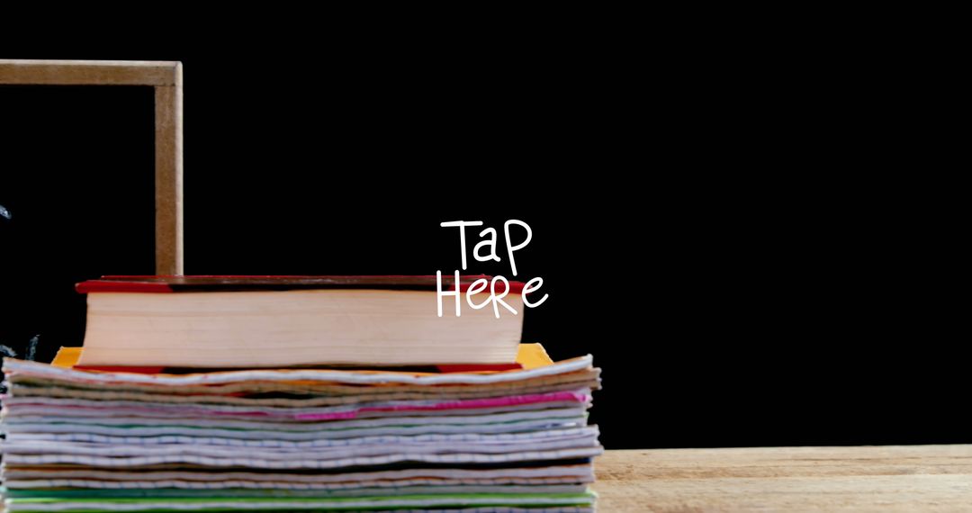Stack of Books and Papers with Interactive Text on Blackboard