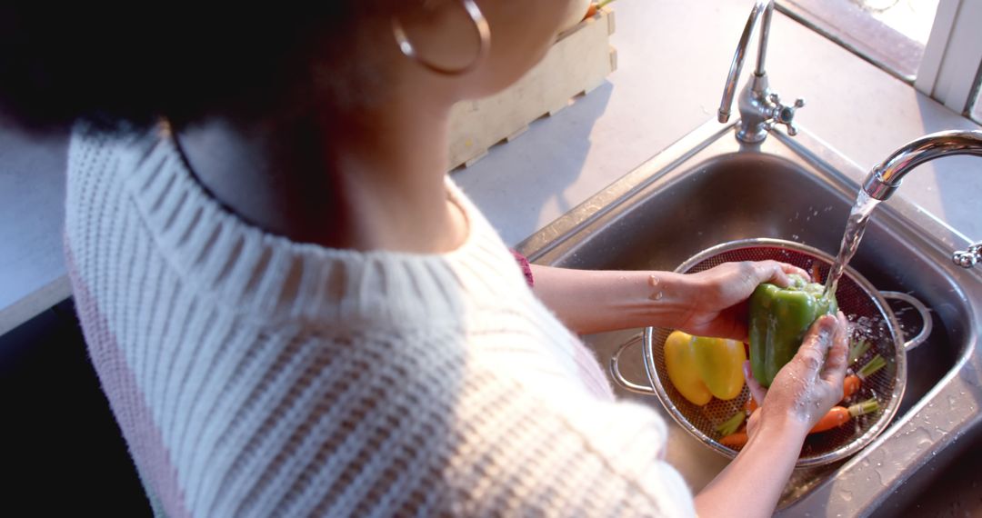 Woman Washing Bell Peppers in Kitchen Sink with Running Water - Free Images, Stock Photos and Pictures on Pikwizard.com