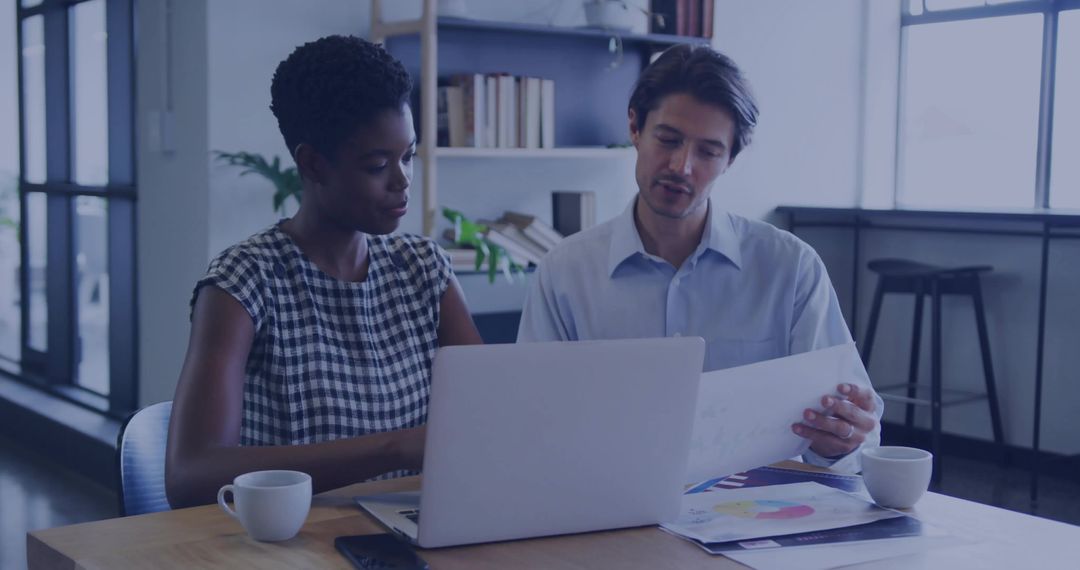 Business Team Collaborating Over Laptop and Color Charts in Modern Office Workspace during Meeting