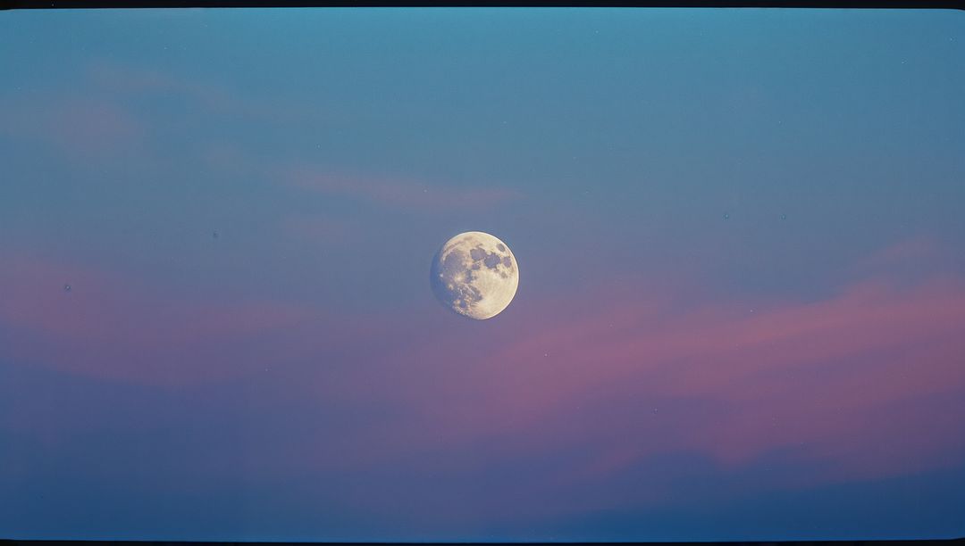 Serene Nearly Full Moon Illuminated in Twilight Sky