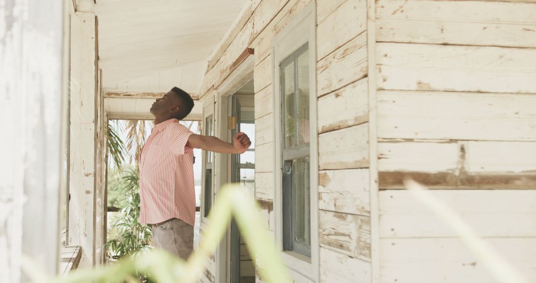 African american man stretching outside house on beach, copy space - Free Images, Stock Photos and Pictures on Pikwizard.com