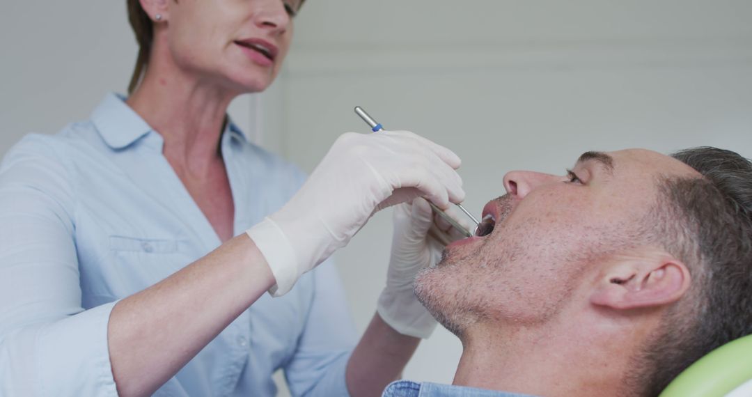 Dentist Examining Male Patient During Checkup Appointment - Free Images, Stock Photos and Pictures on Pikwizard.com